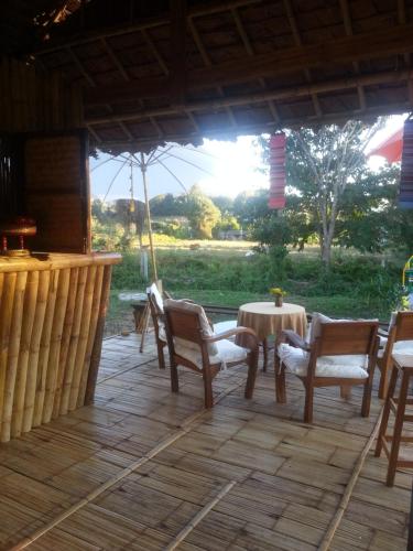 a porch with a table and chairs and a table and chairs at Tulip Resort Pai in Pai