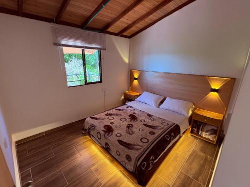 a bedroom with a bed with lights on it at Cabaña Alto Verde in Chiquinquirá