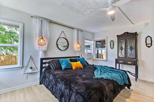a bedroom with a large bed with blue and yellow pillows at Charming St Augustine Oasis with Game Room for Family fun in St. Augustine