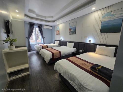 a hotel room with three beds and a television at Hanoi Central Backpackers Hostel in Hanoi