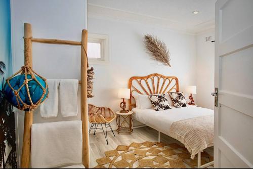 a bedroom with a bed and a chair at Bondi Surf Cottage in Sydney