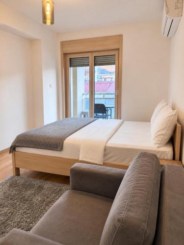 a bedroom with a large bed and a couch at FONTANA DELUXE Apartment in Budva