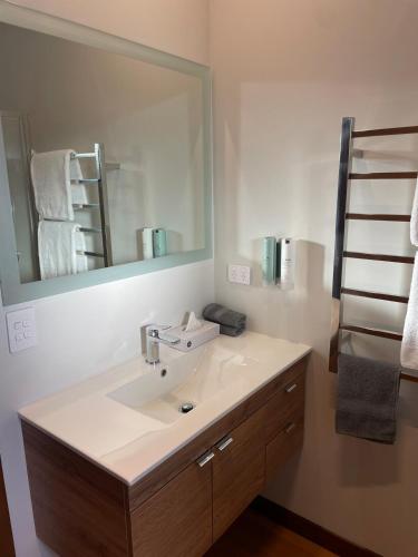 a bathroom with a sink and a large mirror at Whakatā in Te Anau