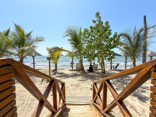 a wooden staircase leading to a beach with palm trees at Despierta en Tolú, un escenario de película in Tolú