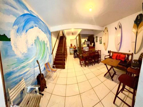 a room with a painting of a wave on the wall at Bouganvile Hostel Ilha Grande in Abraão