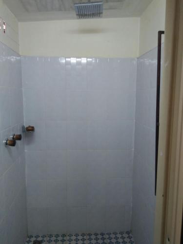 a bathroom with a shower with white tiles at Northern Breeze Hotel in Bagan