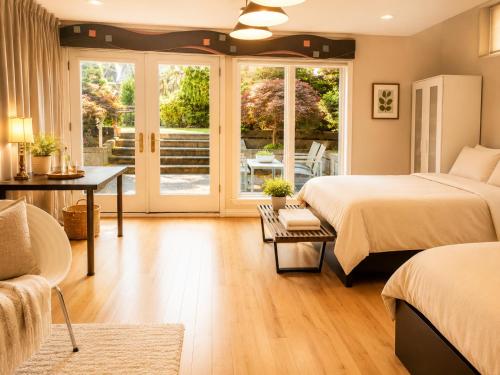 a bedroom with two beds and a desk and a patio at Van Nest near YVR UBC Downtown Free Parking in Vancouver