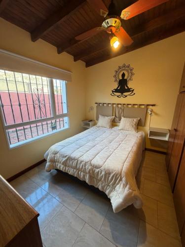 a bedroom with a bed with a ceiling fan and a window at Refugio serrano in Tandil