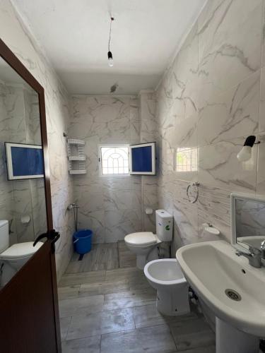 a white bathroom with two toilets and a sink at La Vista Azul in Belyounech 