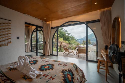 a bedroom with a bed and a large glass window at Stone Ridge Kintamani in Kintamani