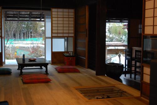 a living room with a table in a room with windows at Goemon Kyoto Japan in Kyoto