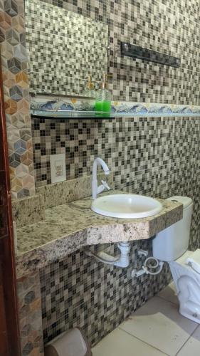 a bathroom with a sink and a toilet at Apartamento aconchegante in Marabá