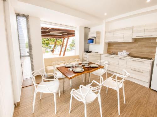 a kitchen and dining room with a table and chairs at Playa Azul Exclusive Suites in Tonsupa