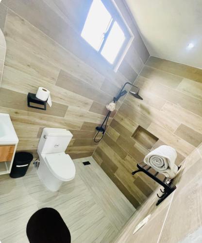 a bathroom with a toilet and a shower with a window at Villa renacer 1 in Baní