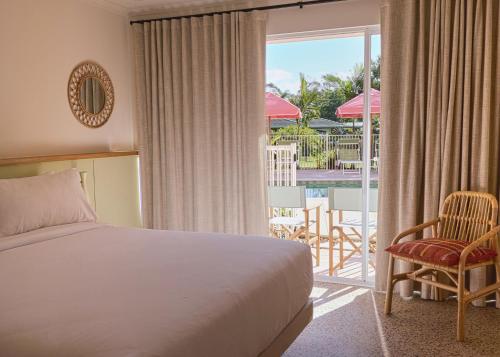 a bedroom with a bed and a balcony with a patio at The Roy in Rainbow Beach