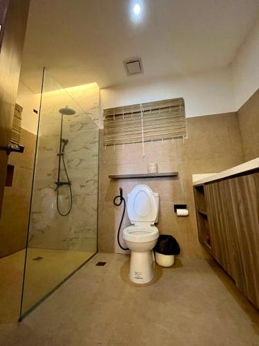 a bathroom with a toilet and a shower at Villa Patria in Calatagan