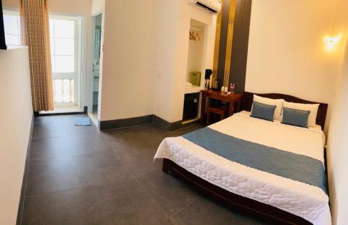 a bedroom with a large bed and a bathroom at khách sạn Quốc Tế in Cà Mau