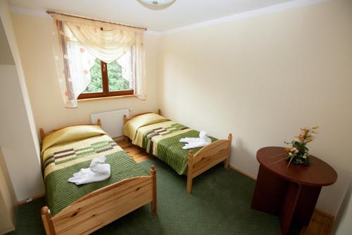 Dos camas en una habitación con toallas. en Ośrodek Wypoczynkowy Sowa en Lipniak
