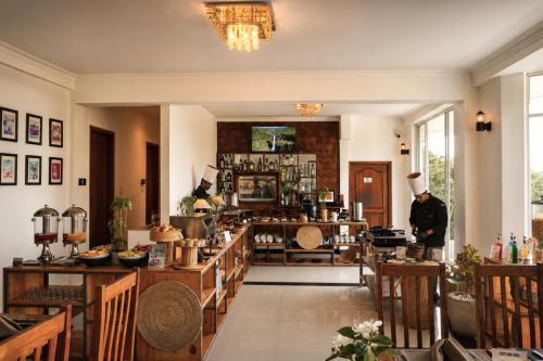 ein Restaurant, in dem ein Koch in einem Raum steht in der Unterkunft Onrock Boutique Hotel in Ella