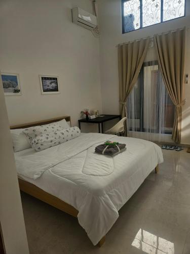 a bedroom with a bed and a window at Kooka Residence Surabaya in Surabaya