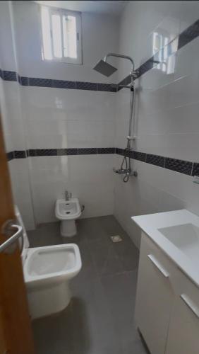 a small bathroom with a toilet and a sink at La résidence des lions in Thiès