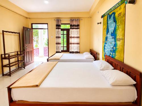 a row of four beds in a room at The Green View Guest House Haputale in Haputale