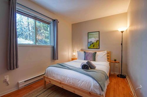 a bedroom with a large bed with a window at Chalet familial, idéalement situé, billard-table-babyfoot-arcade in Saint-Faustin