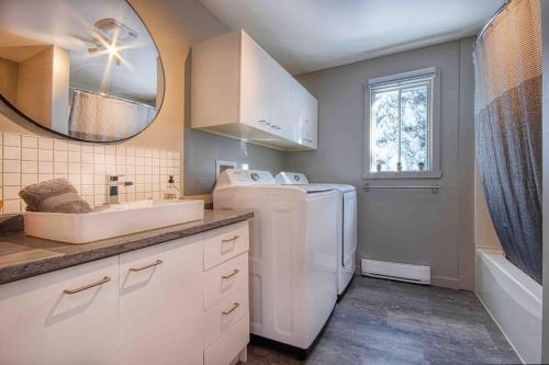 a bathroom with a sink and a washer and dryer at Chalet familial, idéalement situé, billard-table-babyfoot-arcade in Saint-Faustin