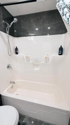 a bathroom with a white tub and a toilet at COZY-Inn in Halifax