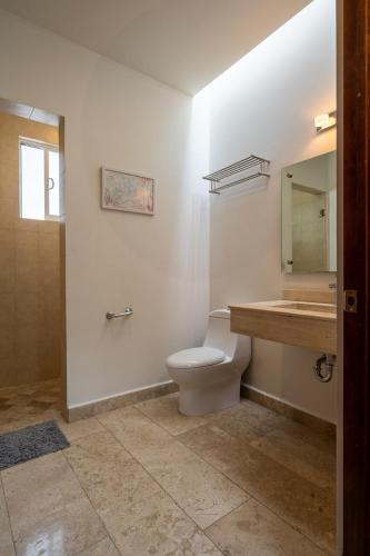 a bathroom with a toilet and a sink and a mirror at Días tranquilos dentro de El Refugio in San José el Alto