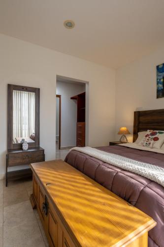 a bedroom with a large bed and a table at Días tranquilos dentro de El Refugio in San José el Alto