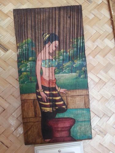 a painting of a woman sitting on a toilet at Tulip Resort Pai in Pai