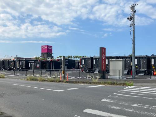 an empty parking lot with a bunch of shipping containers at HOTEL R9 The Yard Hikari in Hikari