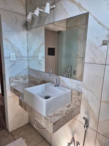 a bathroom with a white sink and a mirror at Casa em Salinas in Salinópolis