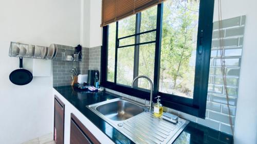 a kitchen with a sink and a window at Naiwok Hills Resort in Haad Pleayleam
