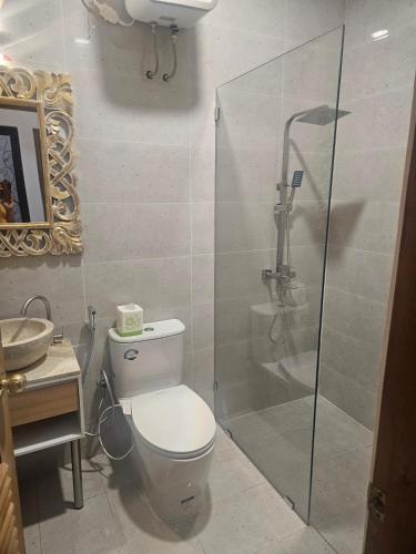a bathroom with a toilet and a shower and a sink at Kooka Residence Surabaya in Surabaya