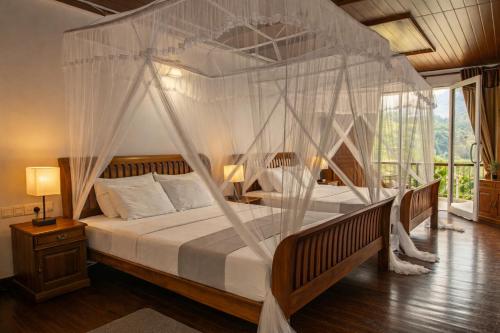 ein Schlafzimmer mit Himmelbett und Moskitonetzen in der Unterkunft Onrock Boutique Hotel in Ella