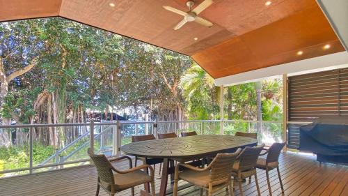 a patio with a table and chairs on a deck at Picnic Bay Apt 3. in Picnic Bay