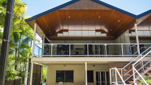 a house with a large balcony with a wooden roof at Picnic Bay Apt 3. in Picnic Bay