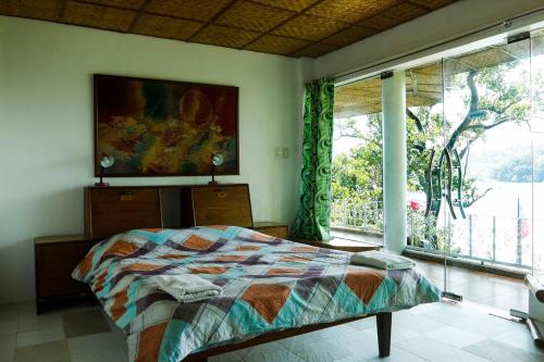 a bedroom with a bed and a large window at Oceanside Villa in Puerto Galera