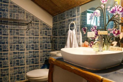 a bathroom with a sink and a toilet at Oceanside Villa in Puerto Galera