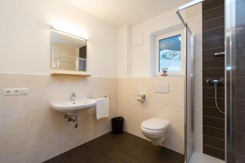 a bathroom with a toilet and a sink and a shower at Ferienhaus Alpenherz in Finkenberg