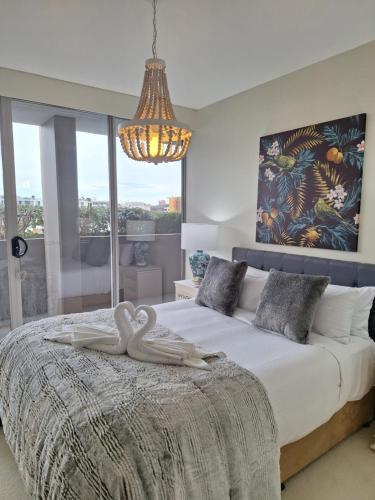 a bedroom with a bed with two swans on it at Honeysuckle Executive Apartments in Newcastle