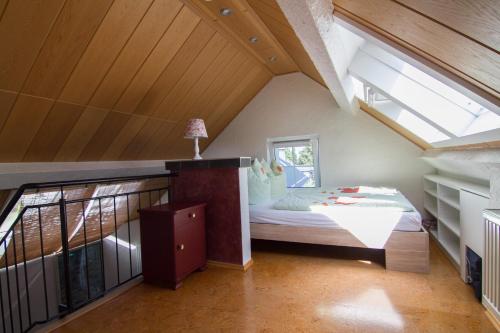 een slaapkamer op zolder met een bed en een raam bij Ferienhaus Wildblick in Schleiden