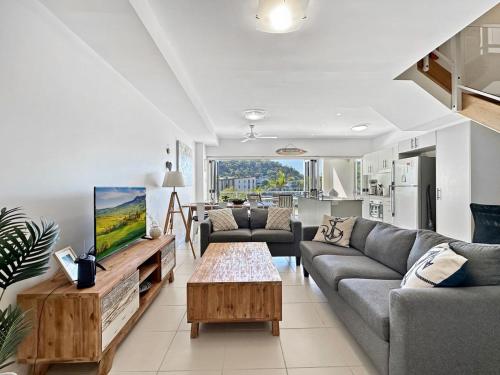 a living room with two couches and a tv at Beachside 17 in Nelly Bay