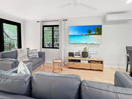 a living room with a couch and a tv on a wall at Alma Rocks in Arcadia