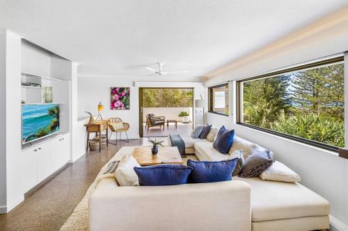 a living room with two couches and a large window at Salt Luxury Location in Sunshine Beach
