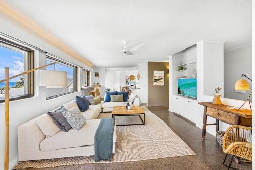 a living room with a white couch and a piano at Salt Luxury Location in Sunshine Beach