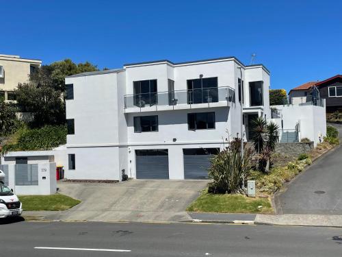 a white apartment building with a parking lot at 379 on Kāpiti in Paraparaumu