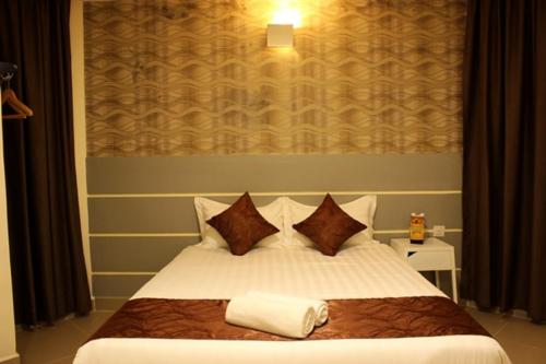 a bedroom with a bed with two towels on it at Rock & Roll Hotel Klang in Klang
